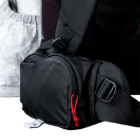 Close-up view of the Outdoor Vitals CS40 Ultra Backpack hip belt pocket, showing the zippered main compartment, cord zipper pull, and adjustable webbing strap.