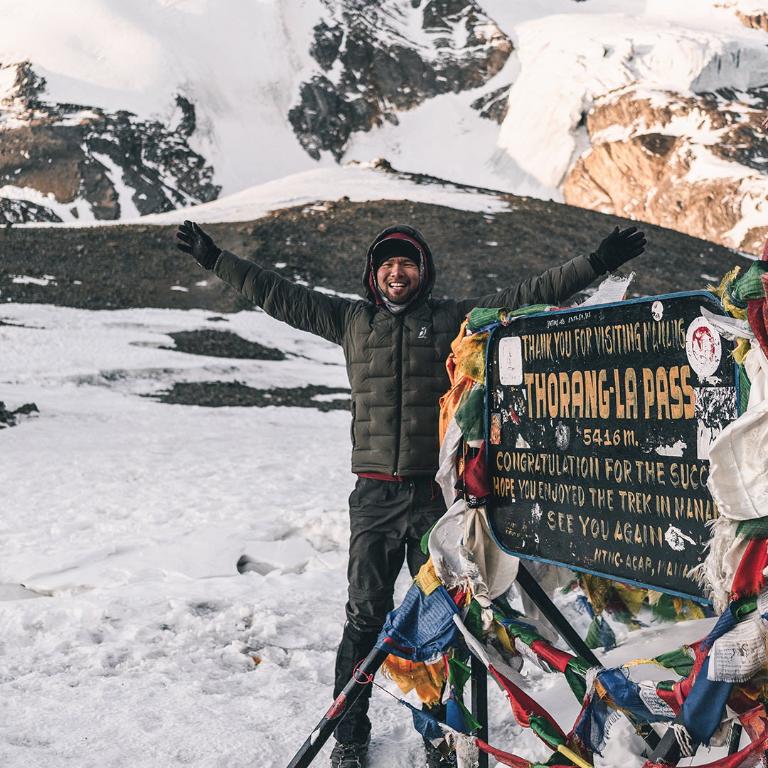 man wearing warm puffy jacket at high mountain pass