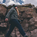 woman wearing dark gray puffy down jacket in high mountain environment.